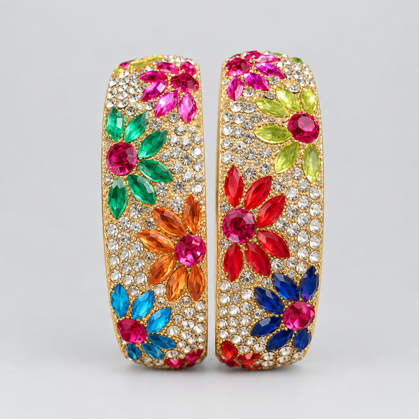 Colorful gemstone bangles on a white cushion with a wooden background
