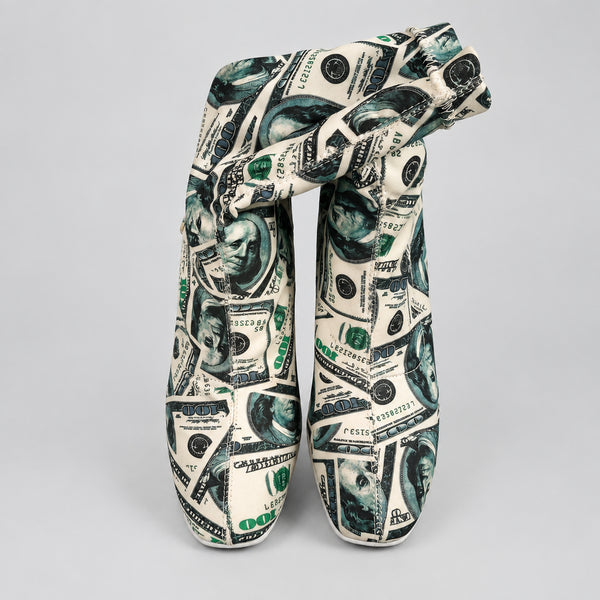 Shoes with dollar bill pattern on a white surface,